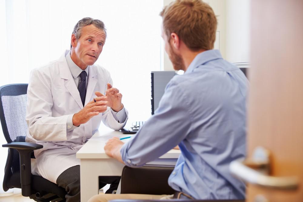 Consultant discussing scan results with a patient at a second-opinion appointment
